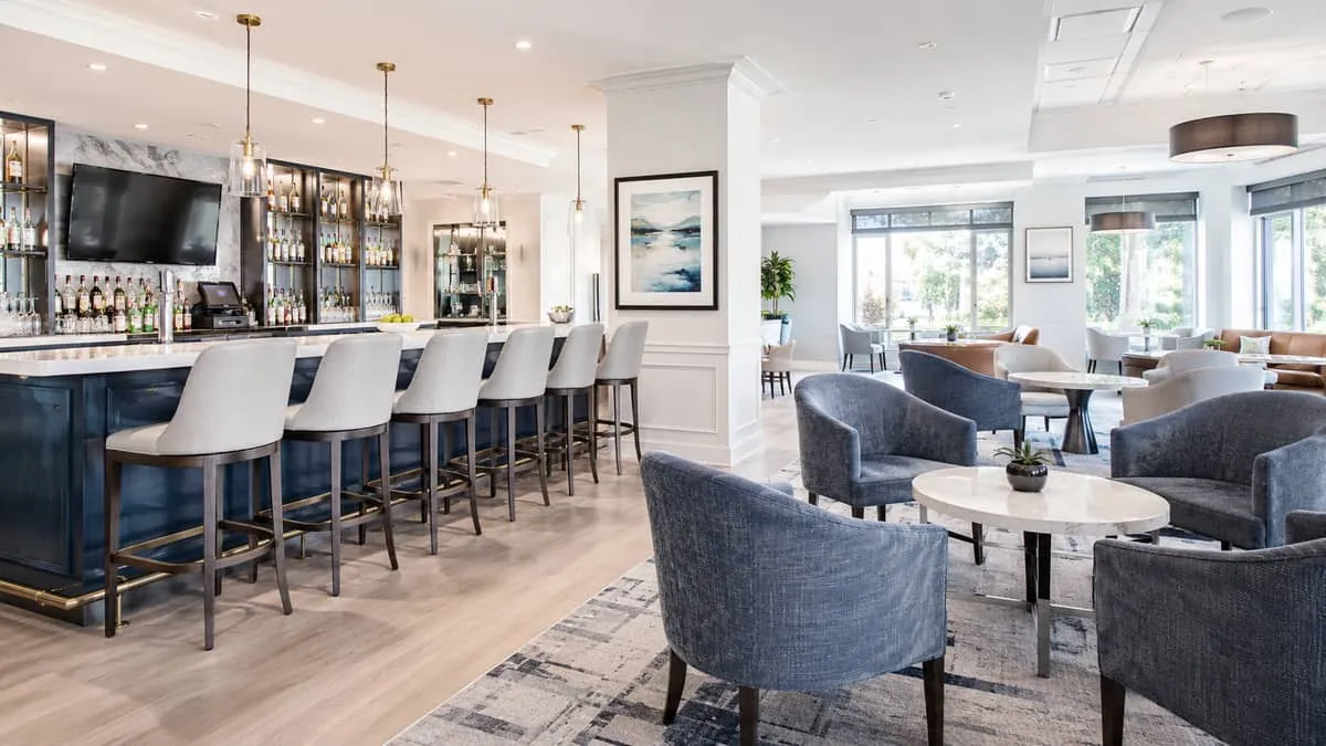 side-by-side comparison of commercial vinyl bar stool seating and fabric lounge chair seating, showing how both can work