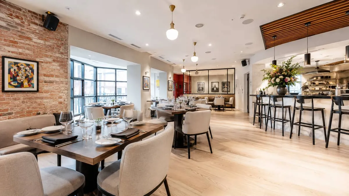 a well-furnished restaurant dining room in an Edmonton arts district setting, showing contract-grade upholstered chairs,