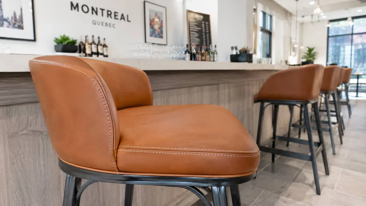 close-up of commercial bar stool upholstery showing a spill-resistant vinyl or faux leather seat with reinforced stitchi