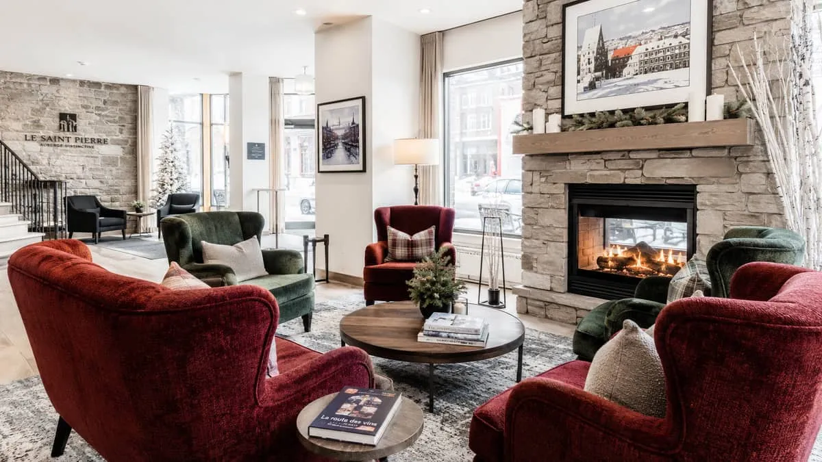 a boutique hotel common area in Quebec City styled for winter ambiance, with robust upholstered armchairs around a firep