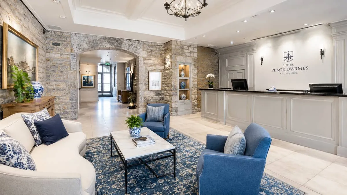 a beautifully finished boutique hotel lobby interior with contract-grade lounge chairs, a reception desk, and warm light