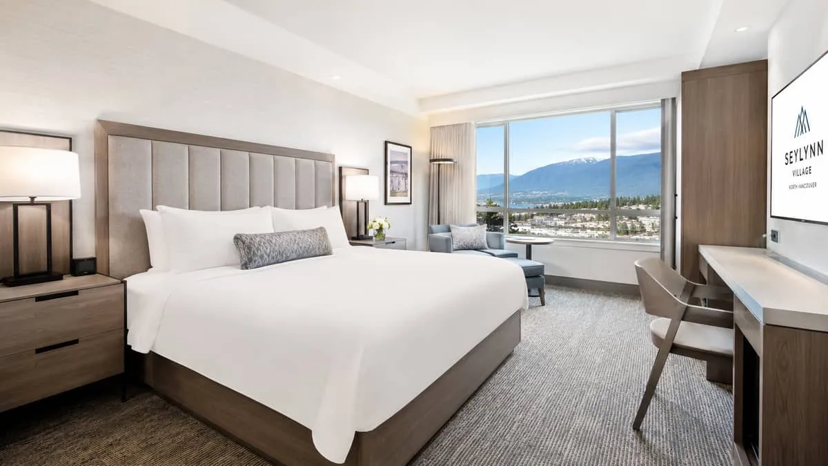 a hotel guestroom in a Vancouver boutique property showing a completed renovation with custom upholstered headboard, mat