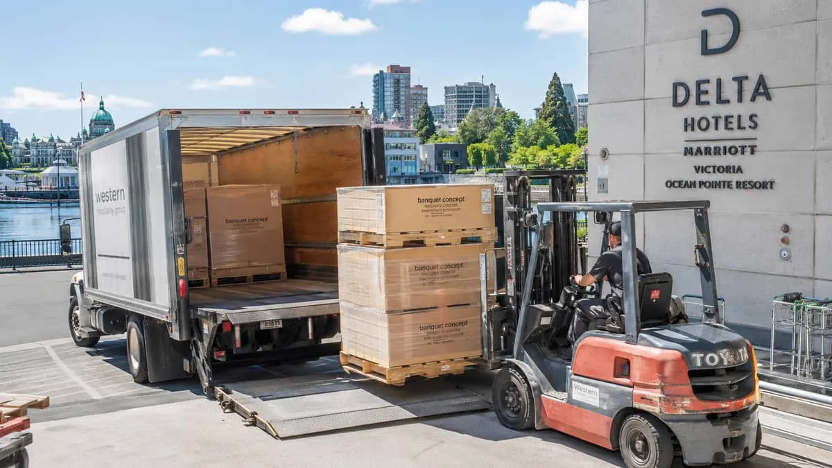 freight delivery of boxed banquet furniture to a Victoria hotel loading dock, forklift visible, Inner Harbour or downtow