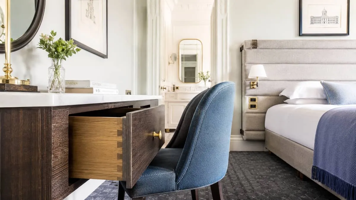 close-up of contract-grade furniture details in a heritage hotel room, showing dovetail joinery on a drawer, commercial-