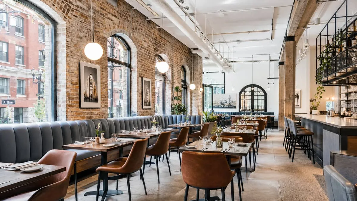 polished restaurant interior in a heritage building, showing well-specified contract furniture including upholstered ban