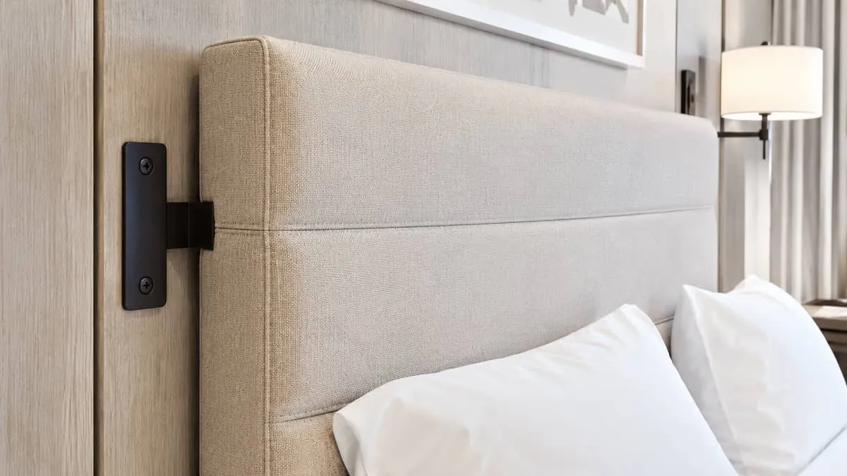 close-up of a commercial hotel headboard with fabric upholstery in a neutral tone, showing the quality of construction i
