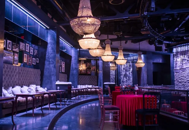 Nightclub bar interior with dark wood and metal furniture showing mixed material bar stools