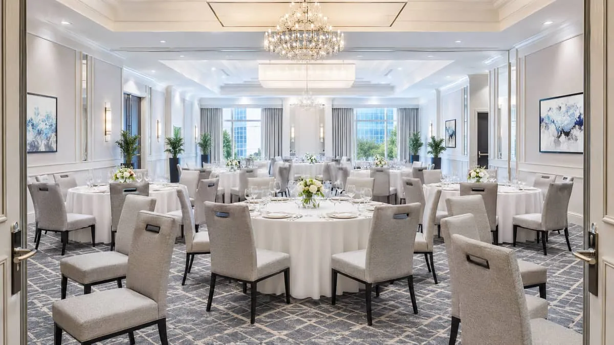 Completed Atlanta hotel ballroom event setup showing uniform banquet chair program with round folding tables dressed for corporate gala